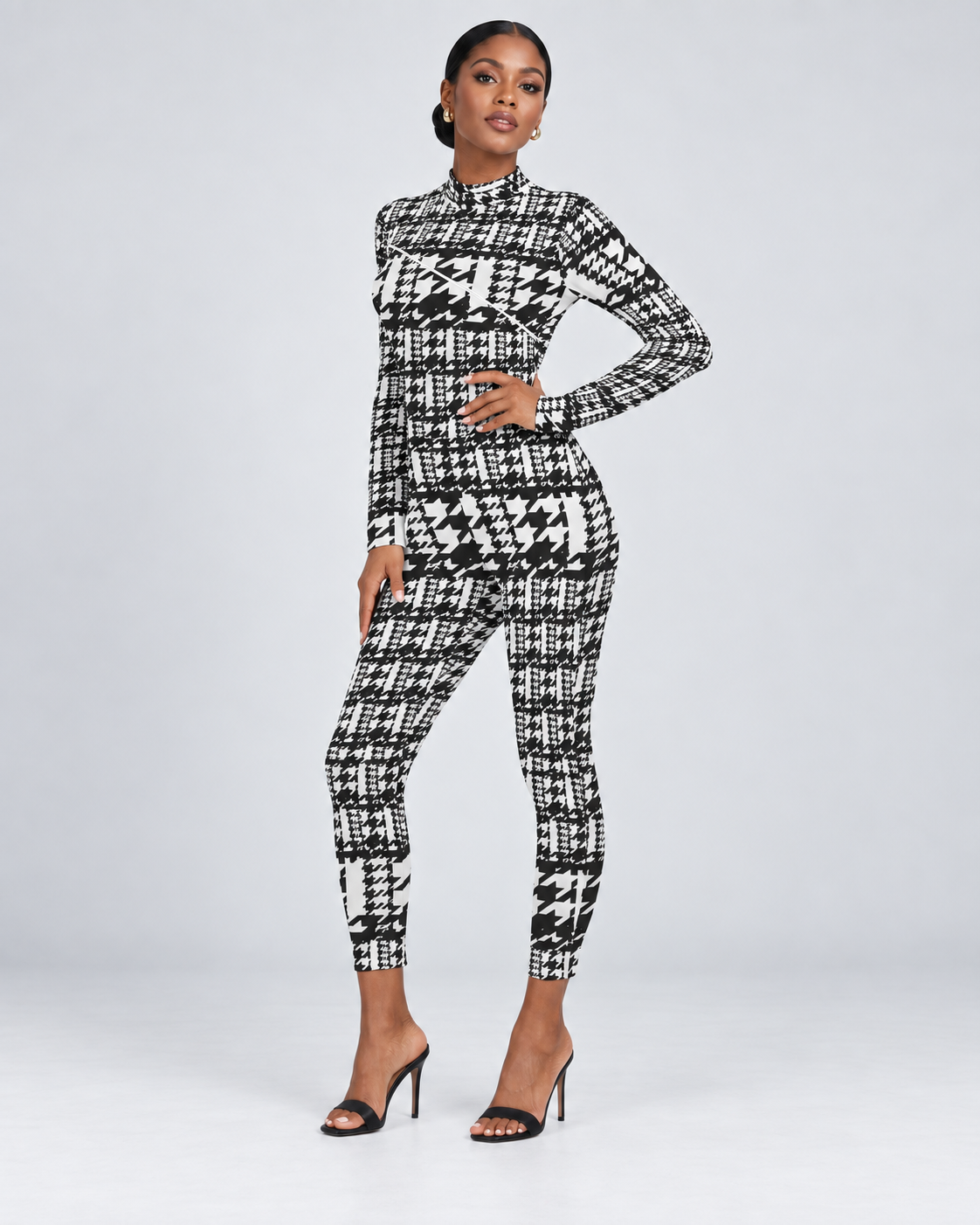 The Houndstooth Remix Jumpsuit — Hand on hip view on a Black model